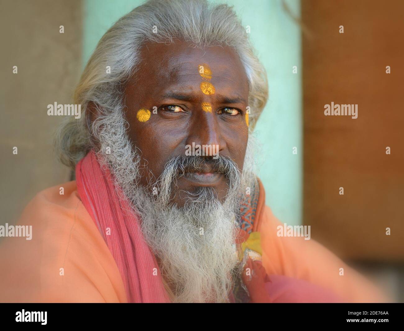 Middle-aged Indian Hindu sadhu (guru, baba) with three yellow tilaka marks on his forehead, one above the other, looks at the camera. Stock Photo