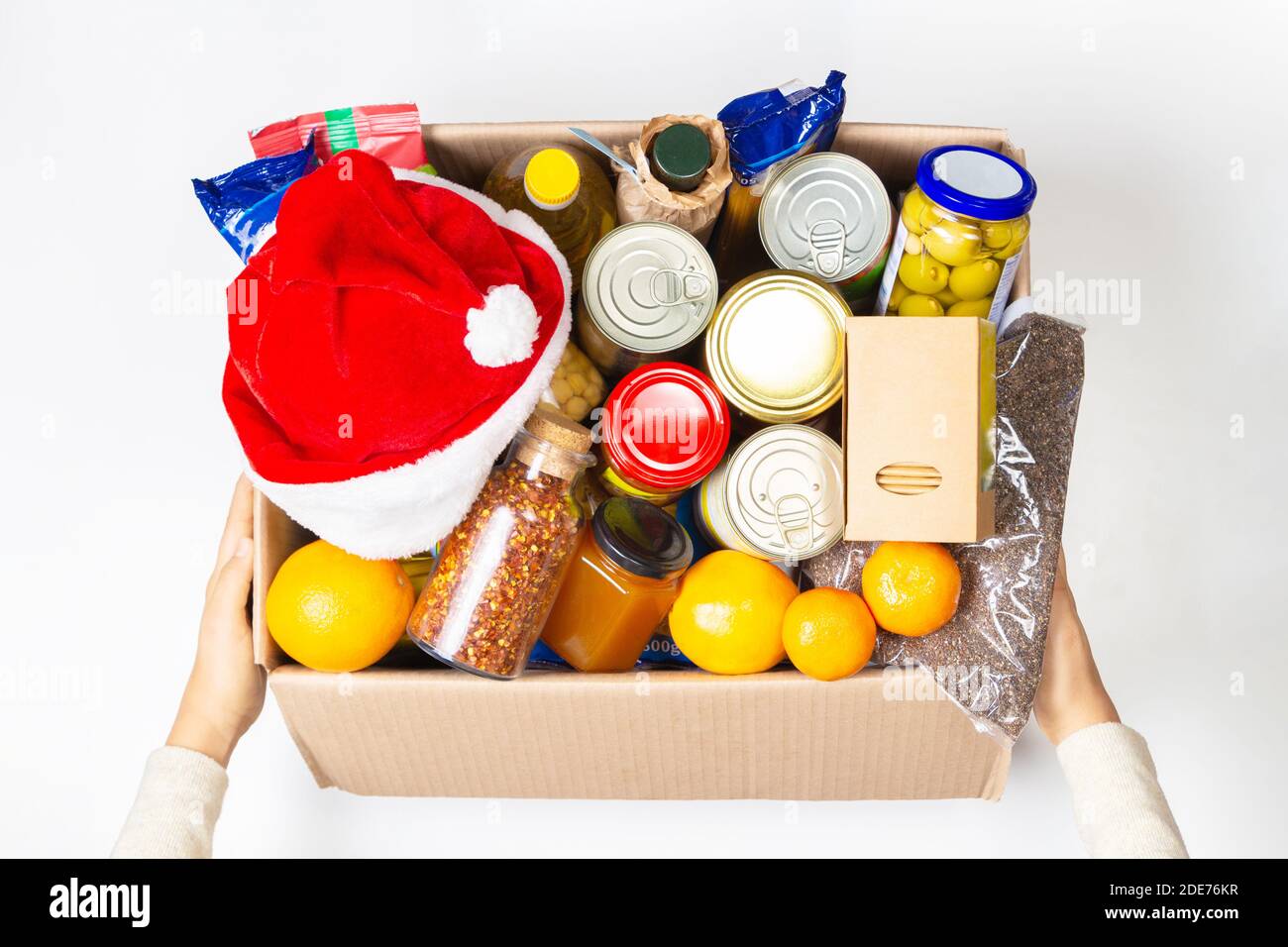 Christmas donation. Food donations box with grocery products on white