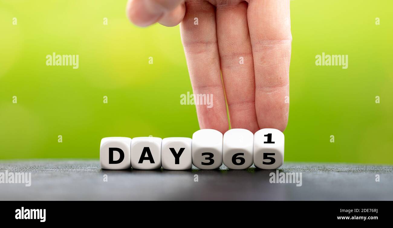 Symbol for a new year. Hand turns dice and changes the expression 'day 365' to 'day 1'. Stock Photo