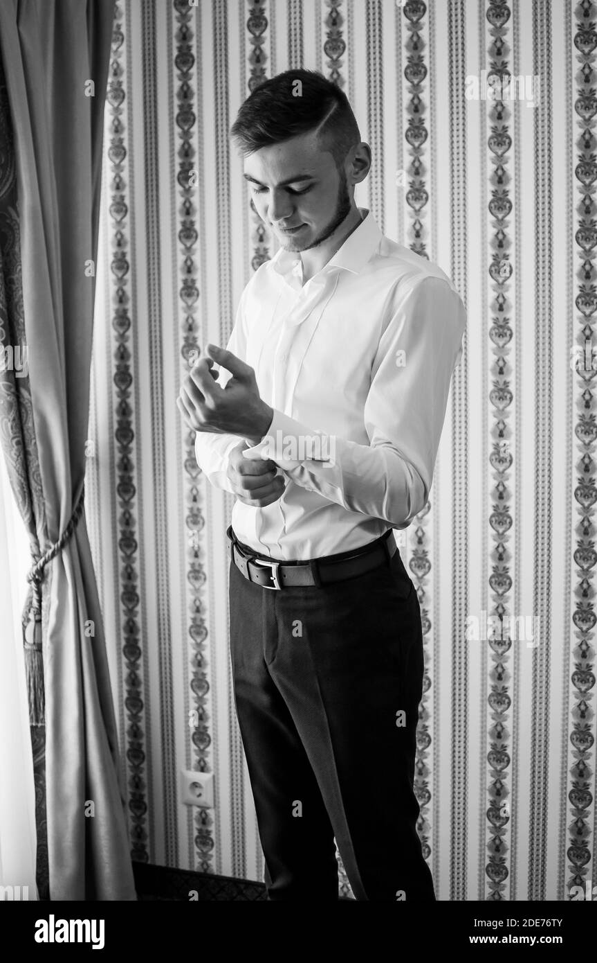 Groom's morning. The groom buttons the cufflinks on his shirt Stock Photo