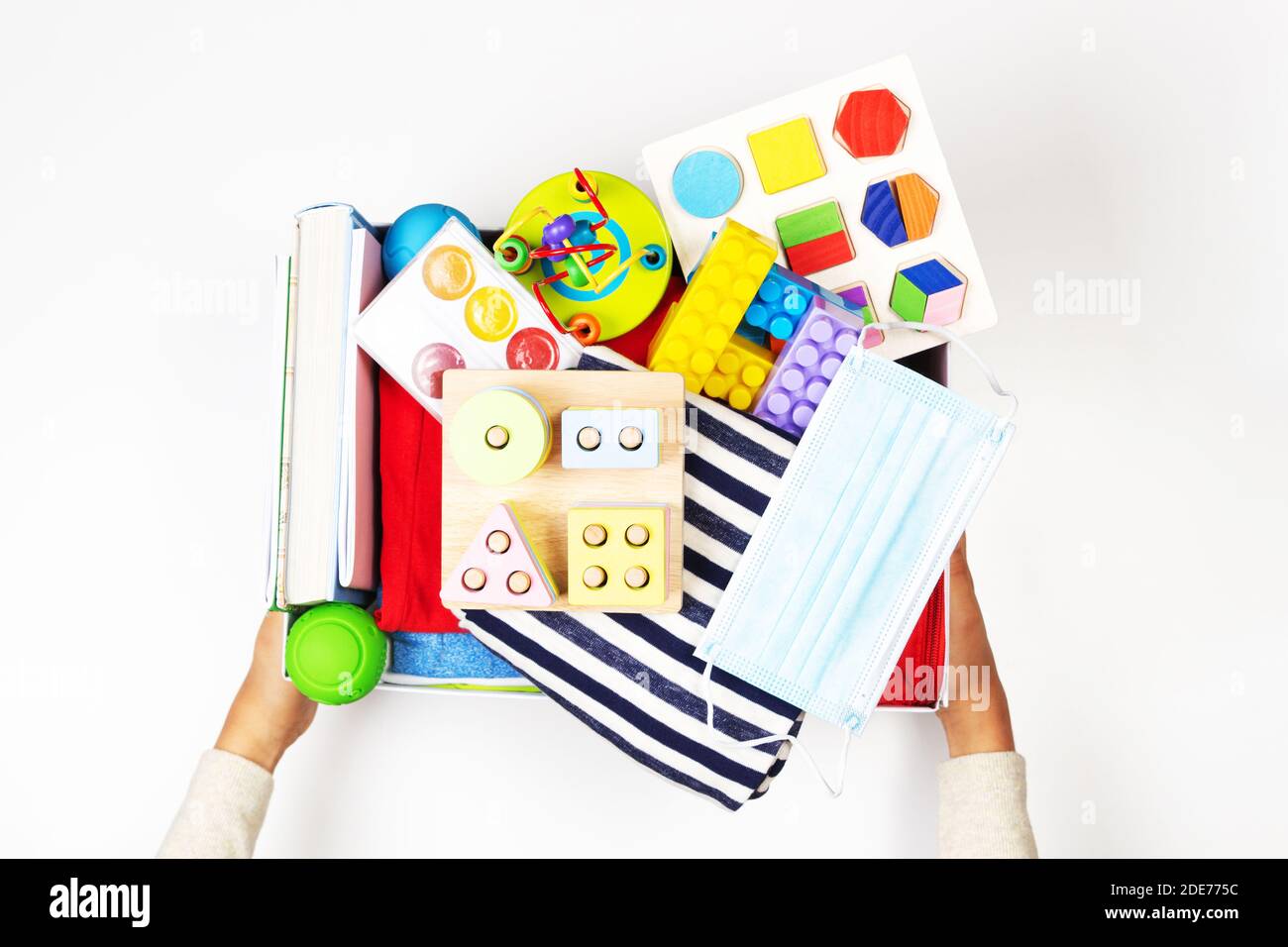 Donation charity concept. Hands holding donate box with clothes, books