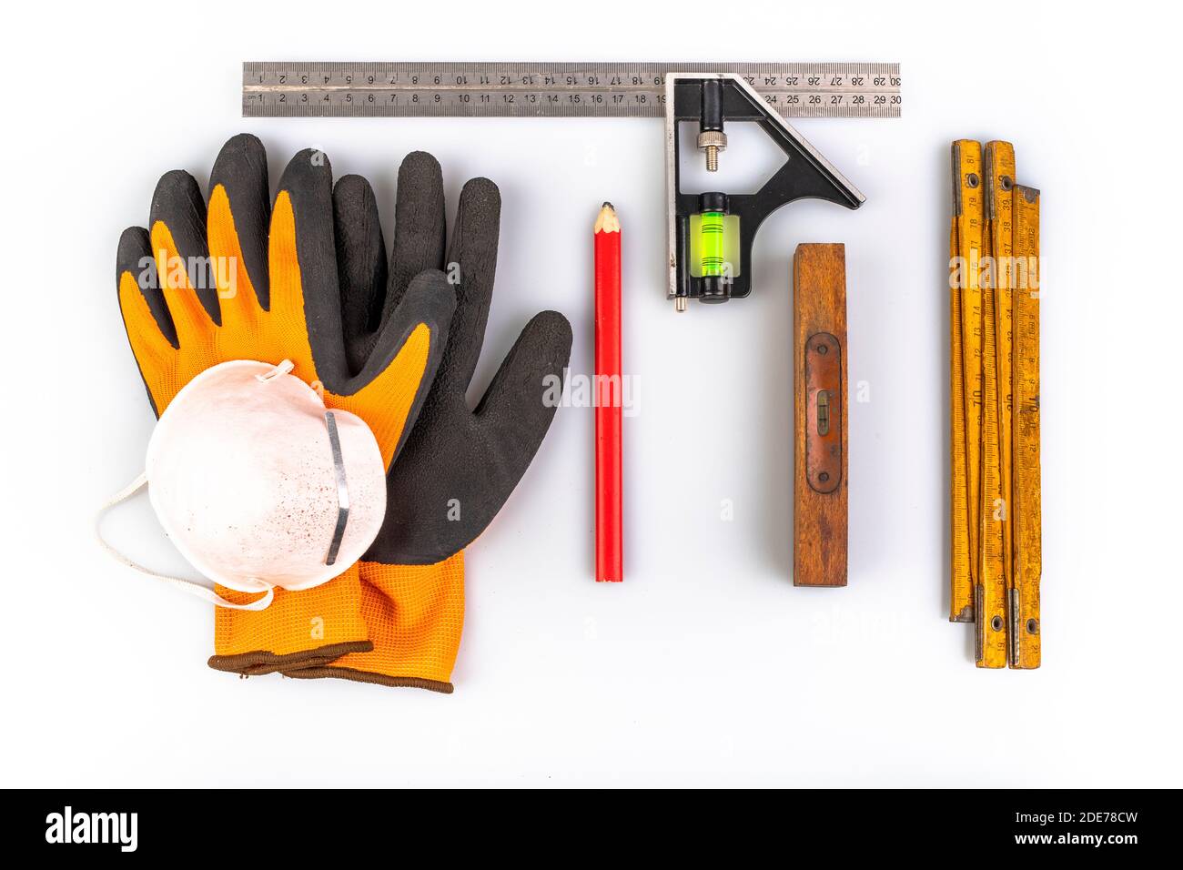 Gloves, tape measure and pencil for carpentry work. Carpentry accessories used in the workshop. Light background. Stock Photo