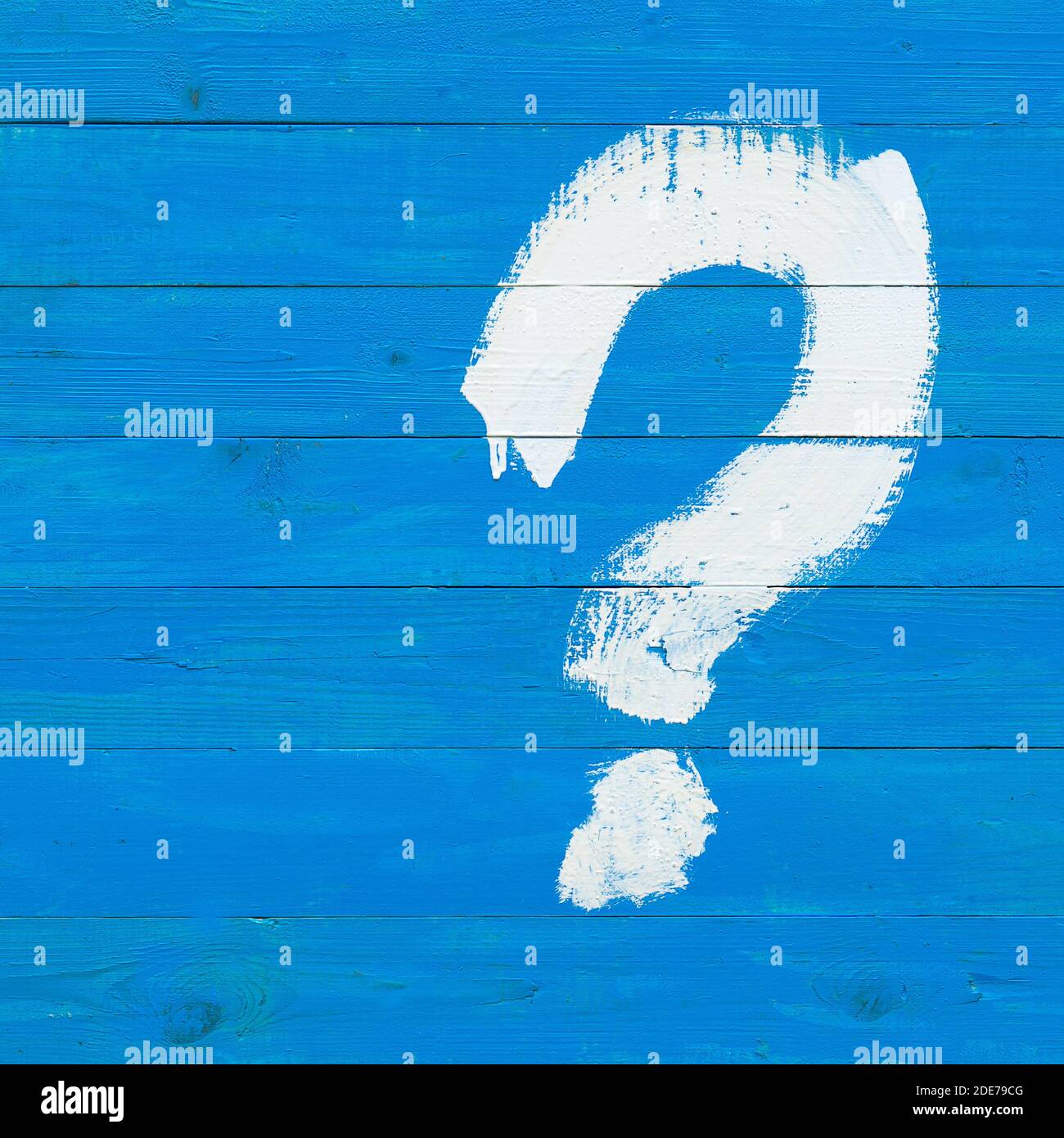 A question mark drawn with a white paint brush on a blue wooden plank