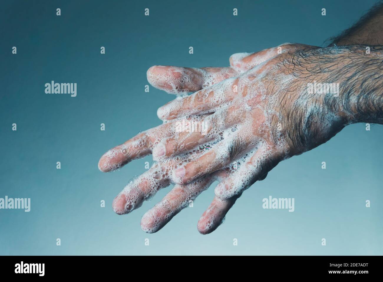 Man washing his hands with soap. Coronavirus transmitted through a hands. Stock Photo