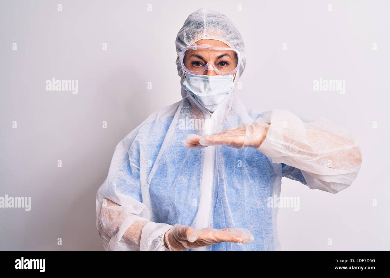 Middle age nurse woman wearing protection coronavirus equipment over ...