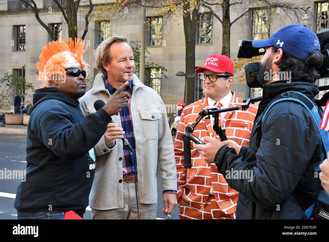 Washington DC. Nov 14, 2020. Million Maga March. Right side news reporter interviewing a black man and a man in 'border wall suit' Mr. Blake Marnell. Stock Photo