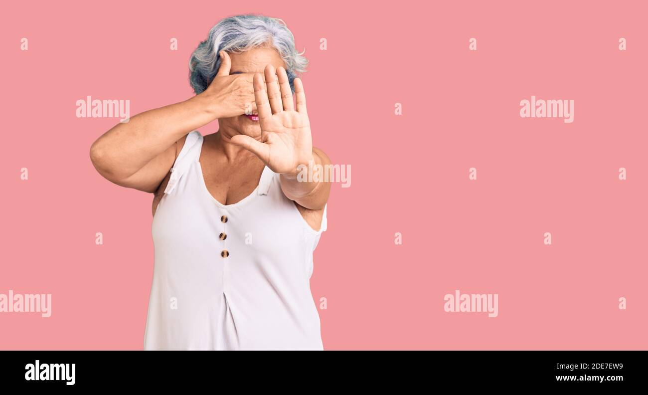 Senior woman with gray hair wearing casual clothes covering eyes with hands and doing stop gesture with sad and fear expression. embarrassed and negat Stock Photo