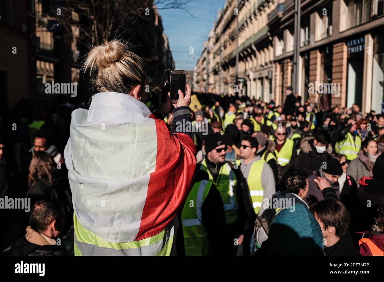 A protester filming the parade live with her smartphone (Facebook Live). In  the wake of the 8th Gilets Jaunes (Yellow Vests) events in Toulouse  (France), the women of the same movement marched