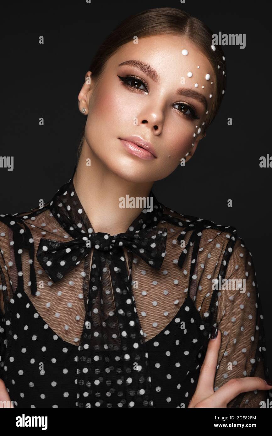 Portrait of a beautiful woman in a black dress with pearls and classic ...