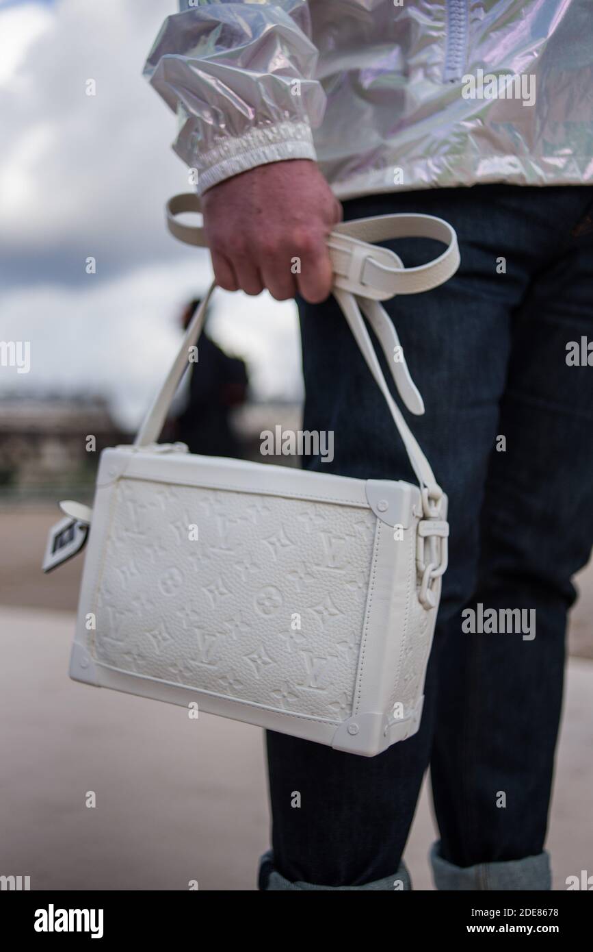 Louis Vuitton Paris Menswear S S Cropped hand holding patterned blue bag  with short handles Stock Photo - Alamy