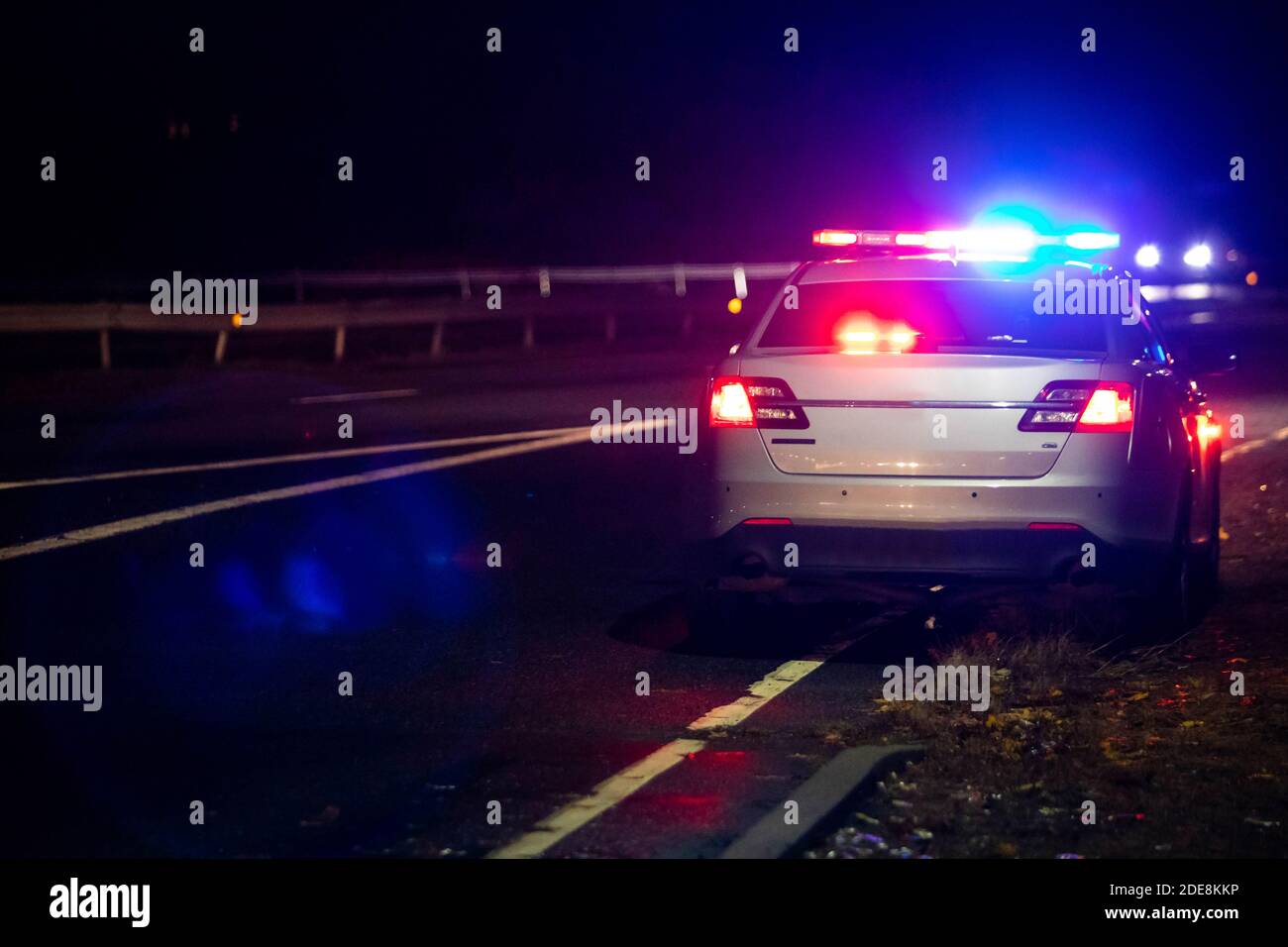 Police emergency flash lights at night from the back on highway Stock Photo