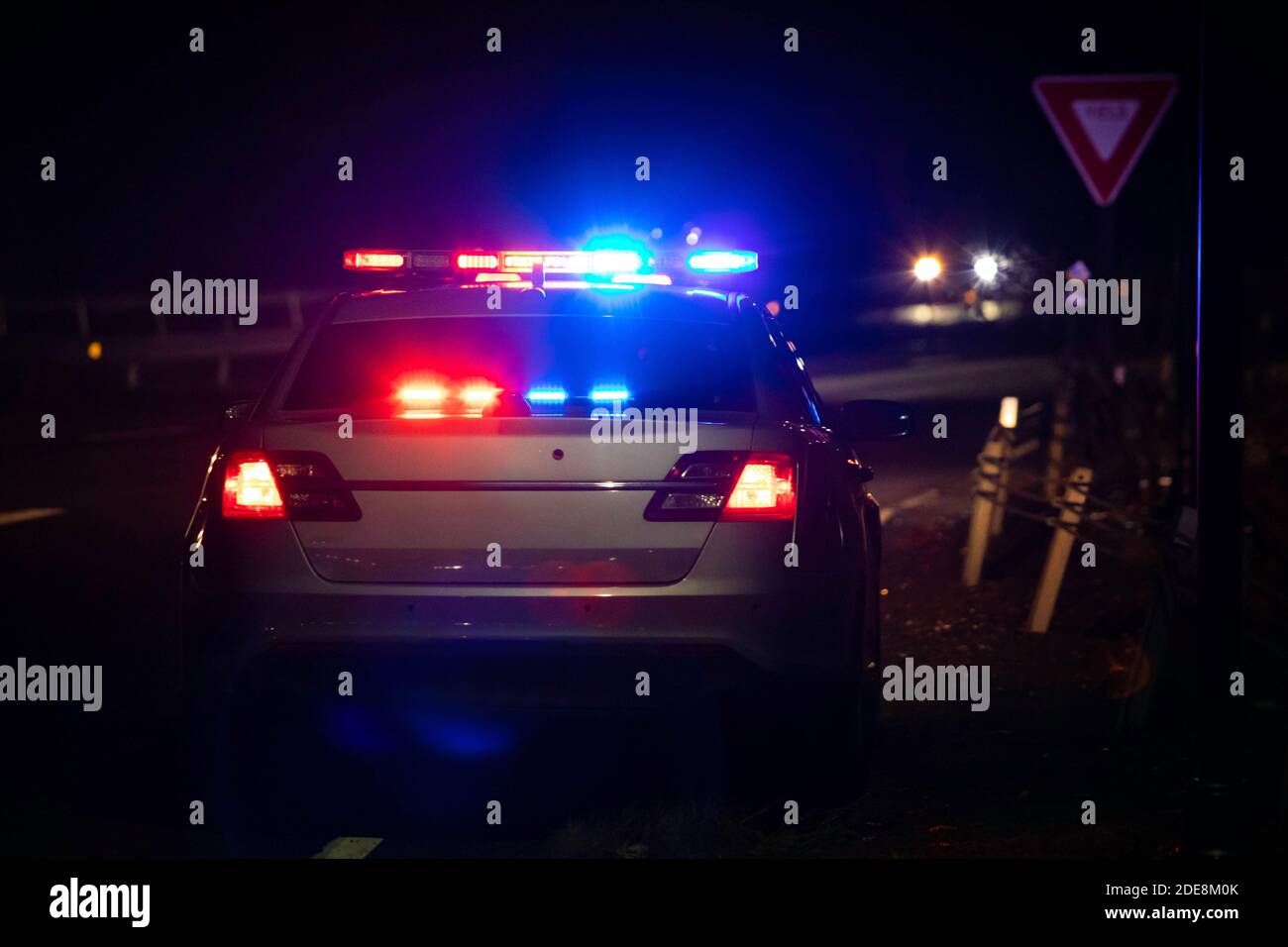 Police emergency flash lights at night from the back on highway road Stock Photo