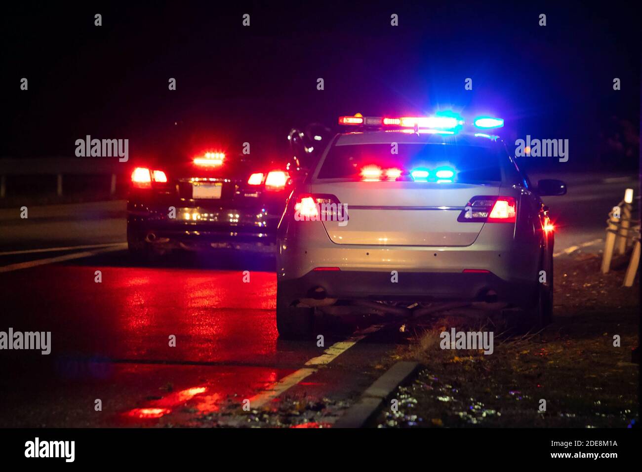 Police emergency flash lights at night from the back on highway road