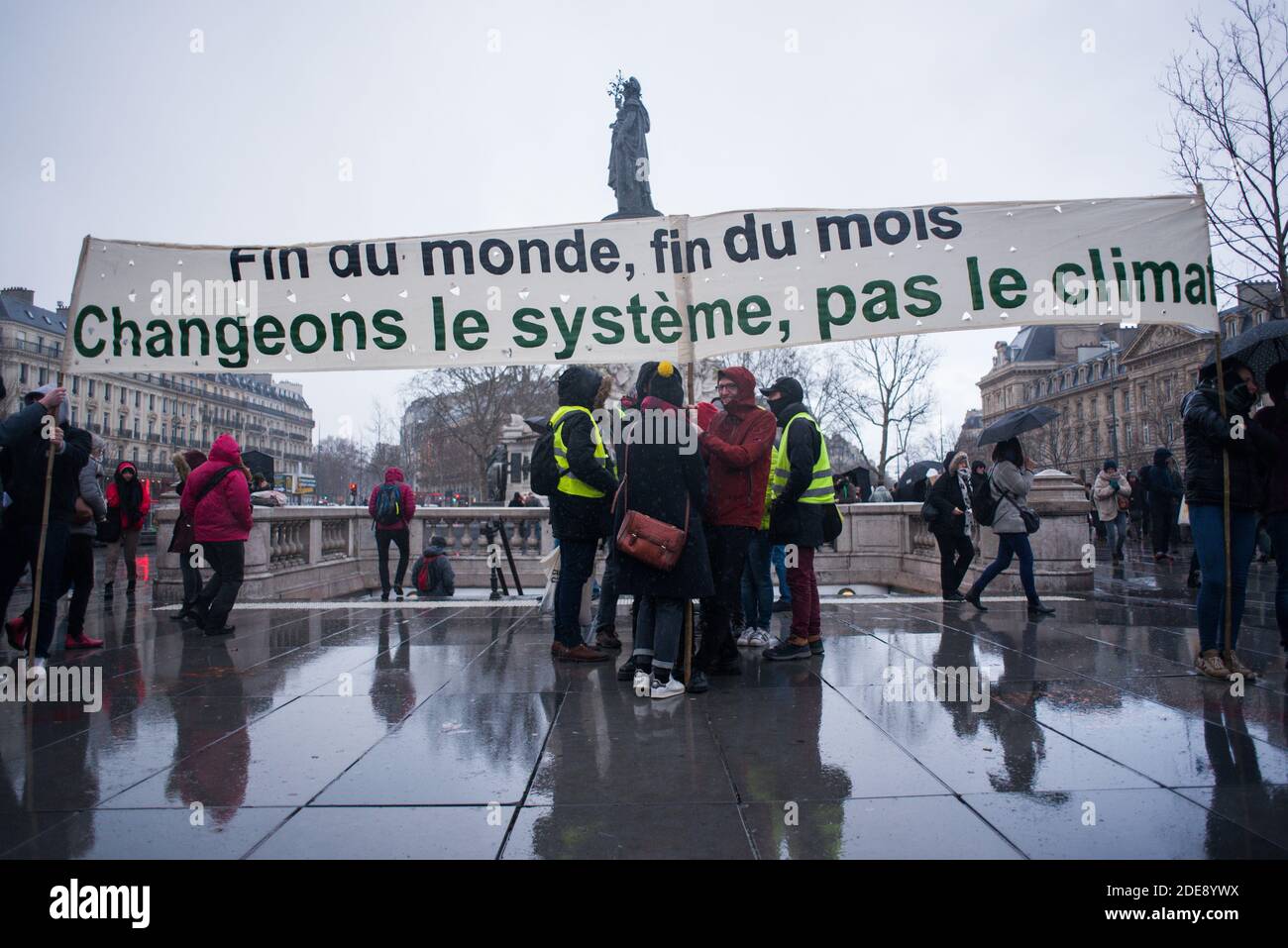 People carry a sign 'End of the world, end of the month, change the system, not the climate' during a gathering for climate in Paris, France, on January 27, 2019. Photo by Julie Sebadelha/ABACAPRESS.COM Stock Photo