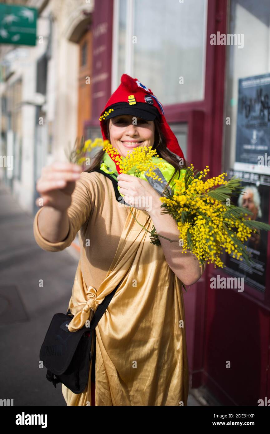Women with a phrygian cap ( Bonnet Phrygien ) distribute yellow flowers  during a demonstration in Paris on February 9, 2019 as the "Yellow Vests" (Gilets  Jaunes) protesters take to the streets