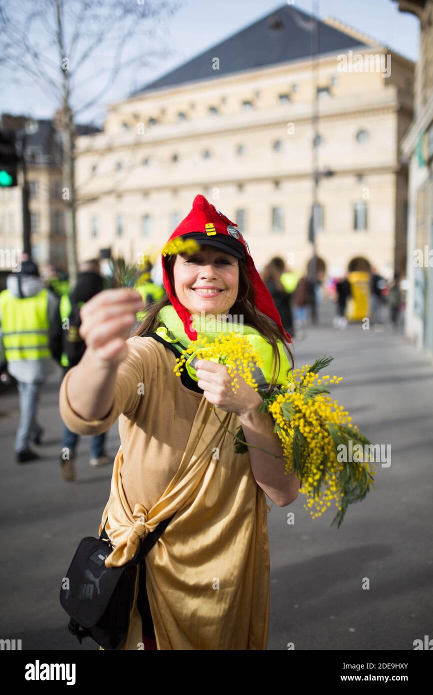 Women with a phrygian cap ( Bonnet Phrygien ) distribute yellow flowers  during a demonstration in Paris on February 9, 2019 as the "Yellow Vests"  (Gilets Jaunes) protesters take to the streets