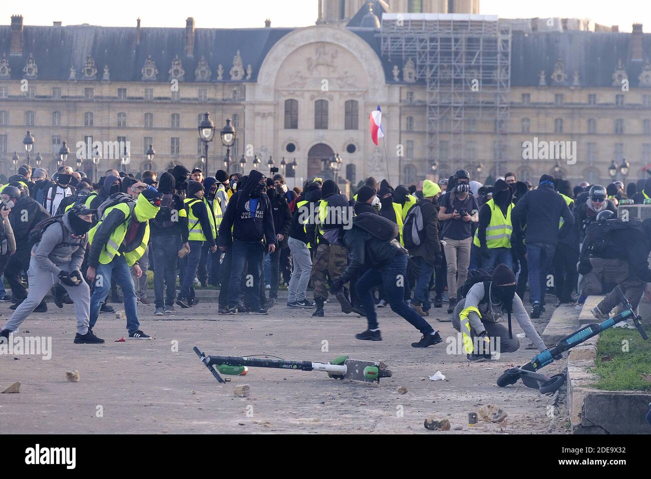 French yellow vests (Gilets jaunes) protesters throw stones during clashes  with French riot police on the Esplanade des Invalides during the 14th  consecutive week of nationwide Yellow Vest (Gilets Jaunes) movement protests