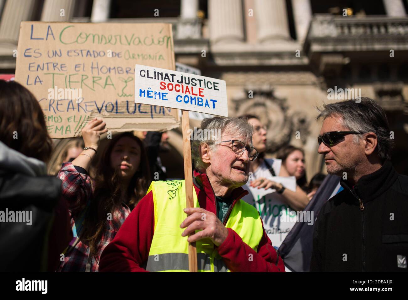 A yellow vest gilet jaune holds a sign "Climate, social justice, same  fight" (Climat justice sociale meme combat) during the march for the  environment and the climate organised by students, in Paris