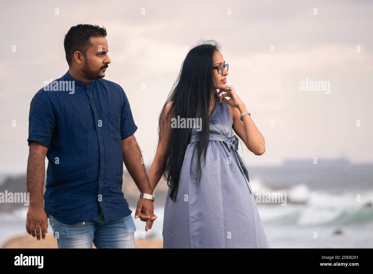 South Asian, Sri Lankan couple Holding hands in the evening, looking at the sunset, maternity fashion, expectations of a child. Stock Photo