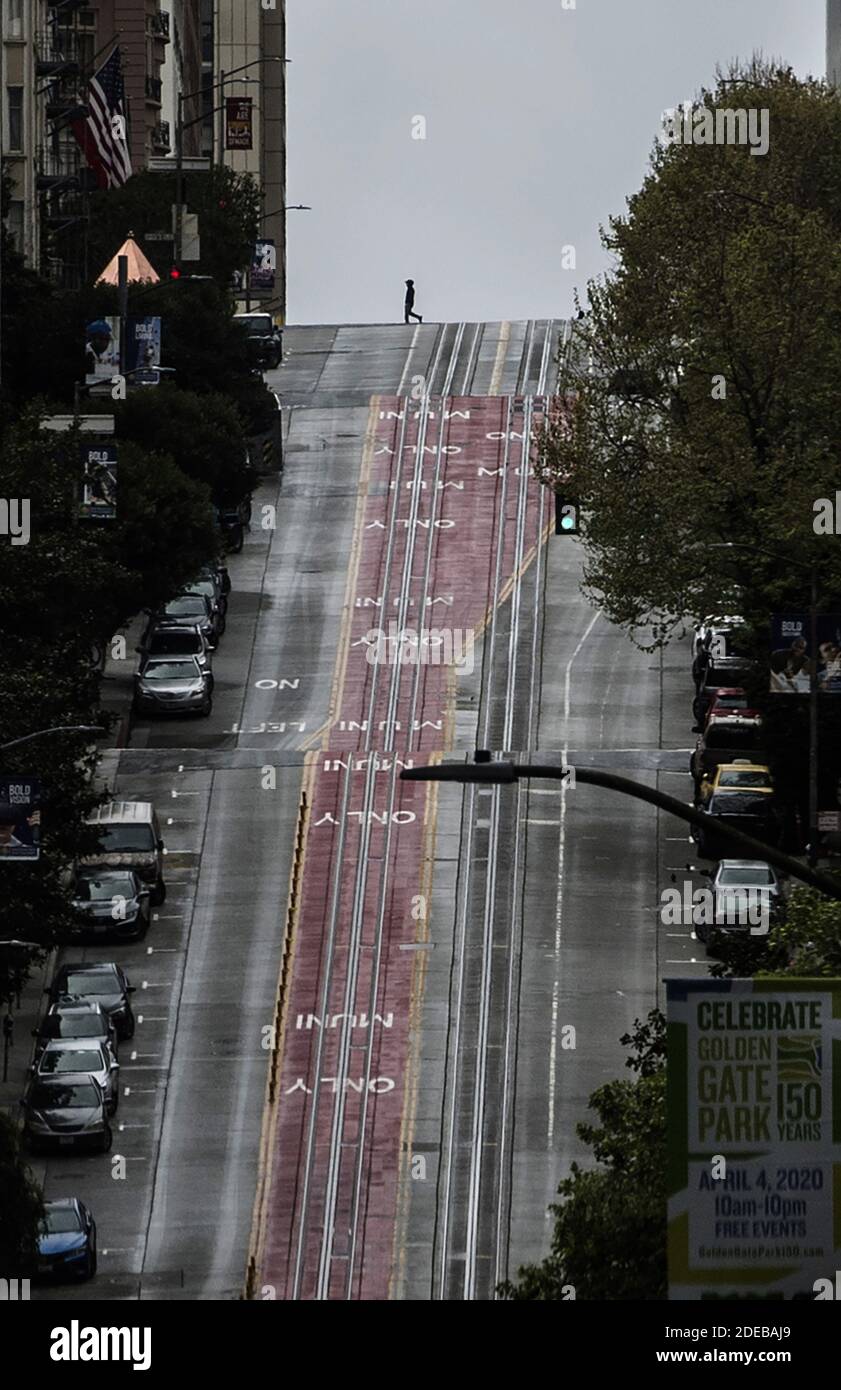 A pedestrian crosses California Street in San Francisco on Sunday, March 29, 2020. The city has shut down Cable Car service and ordered its citizens to shelter in place be cause of Coronavirus. Photo by Terry Schmitt/UPI Stock Photo