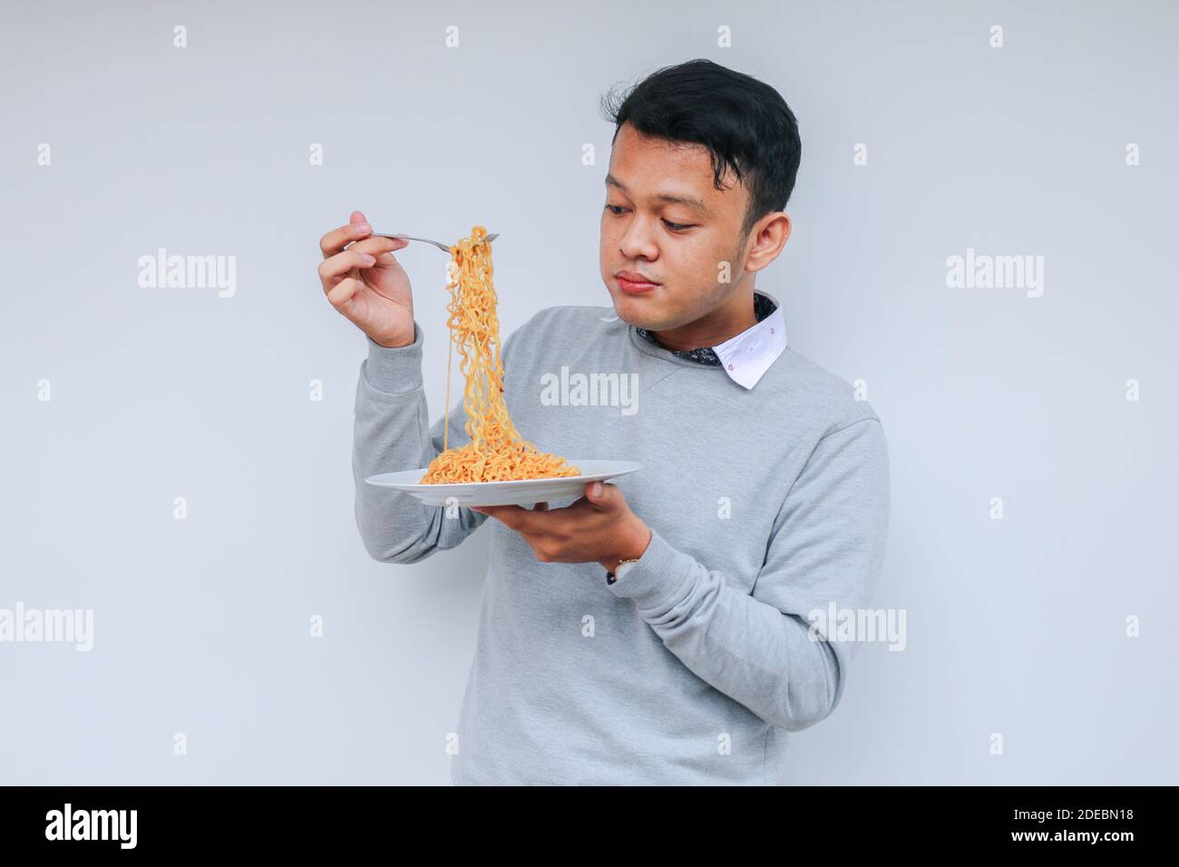 Young Asian man enjoy noodles. Eating lunch concept. Stock Photo