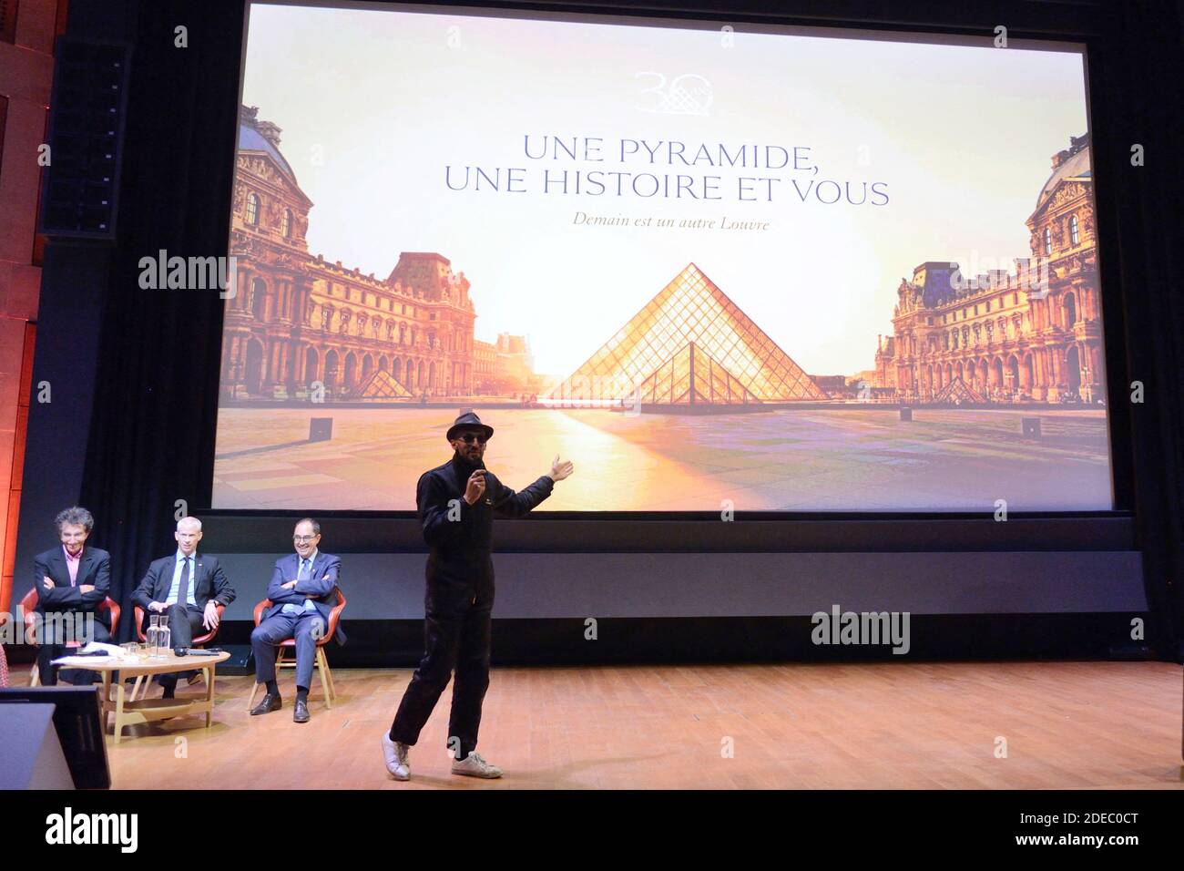 JR attending the 'JR au Louvre & Le Secret de la Grande Pyramide' : Photographer and artist Jean Rene, aka JR, creates a monumental Piece of Art on the scale of Napoleon Court of the Louvre Museum on March 29, 2019 in Paris, France. As part of the celebrations of the 30th anniversary of the Louvre Pyramid, the street artist JR proposes a giant collage to bring out the Pyramid of the Louvre by revealing the foundations of the Napoleon courtyard where it is erected. Photo by Aurore Marechal/ABACAPRESS.COM Stock Photo