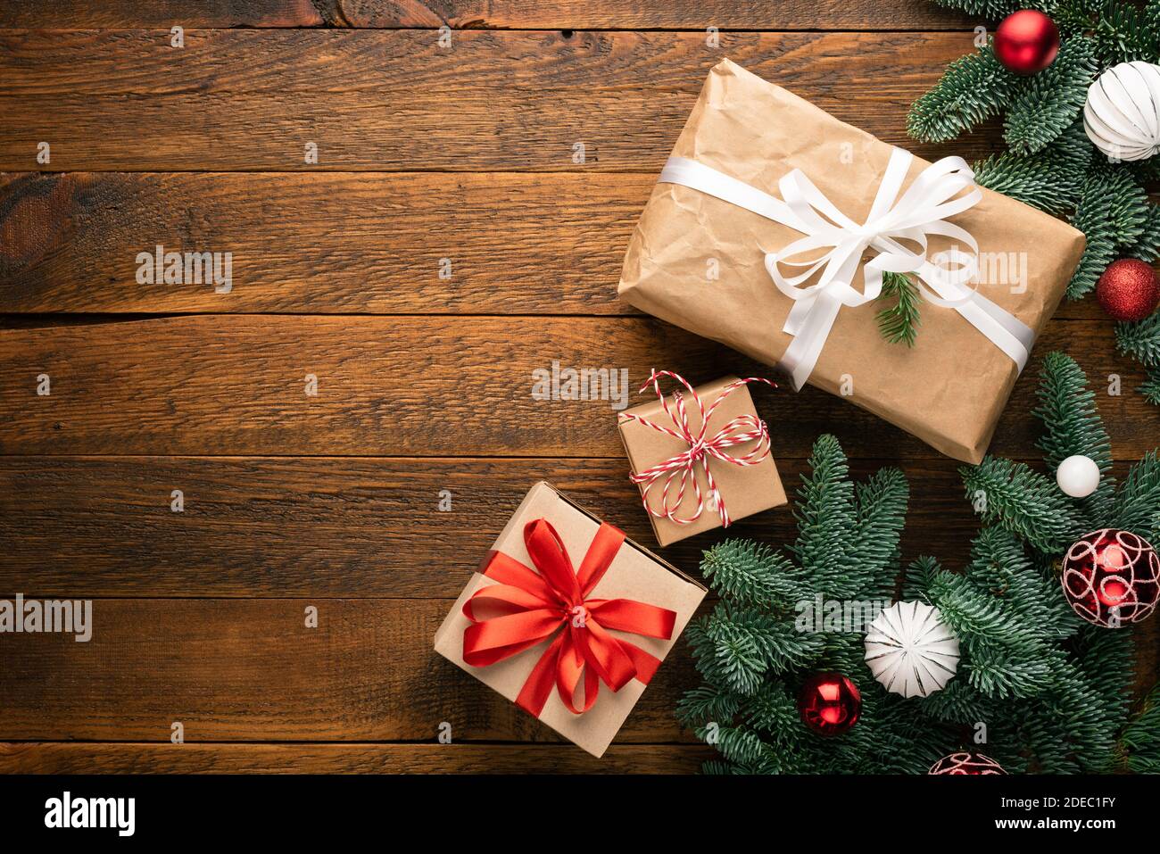 Christmas Gift Boxes On Wooden Background Near Christmas Fir Tree. Top View Copy Space Stock Photo
