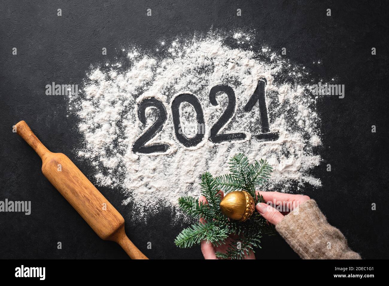 2021 written with flour on black background, top view. New Year, Christmas greeting concept Stock Photo
