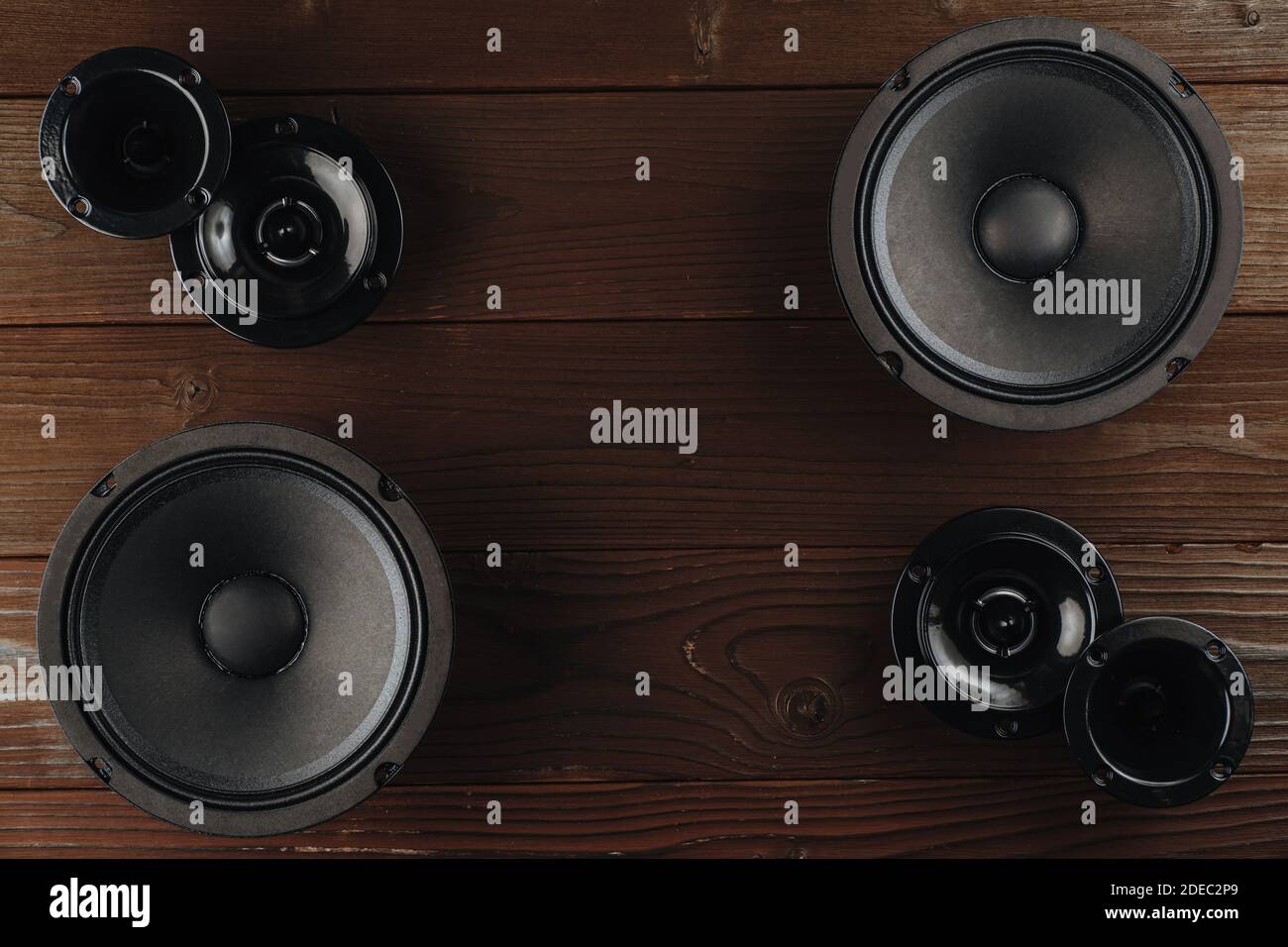 Car audio, black car speakers lie on a brown wooden background. Stock Photo