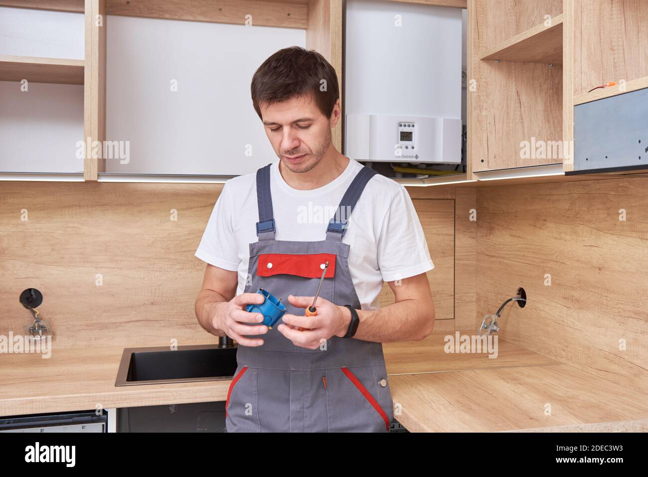 Electrician Installing A Socket Plug In The Kitchen Renovation Concept Electrician Installing A Socket Plug In The Kitchen Renovation Concept