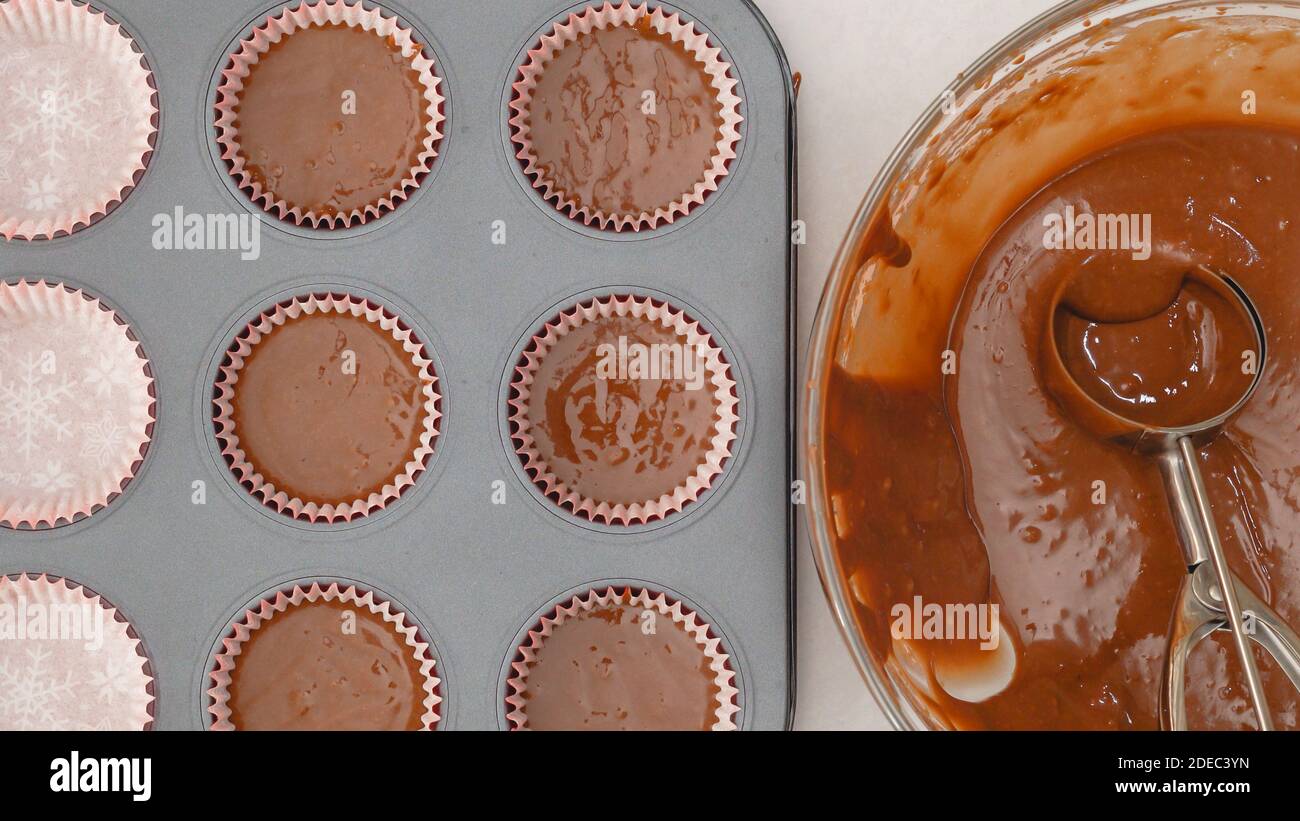 https://c8.alamy.com/comp/2DEC3YN/using-an-ice-cream-scoop-to-pour-cake-batter-into-lined-cupcake-pan-chocolate-cupcakes-with-chocolate-frosting-step-by-step-recipe-2DEC3YN.jpg