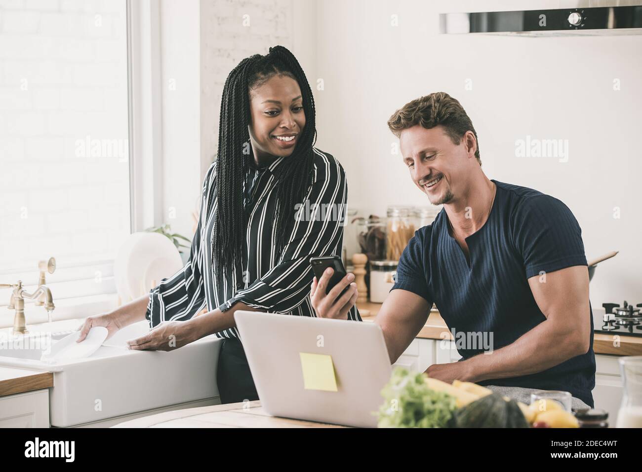 Happy married life morning routine of interracial couple in the kitchen at home Stock Photo
