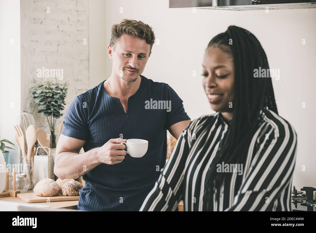 Married life morning routine of interracial couple in the kitchen at home Stock Photo