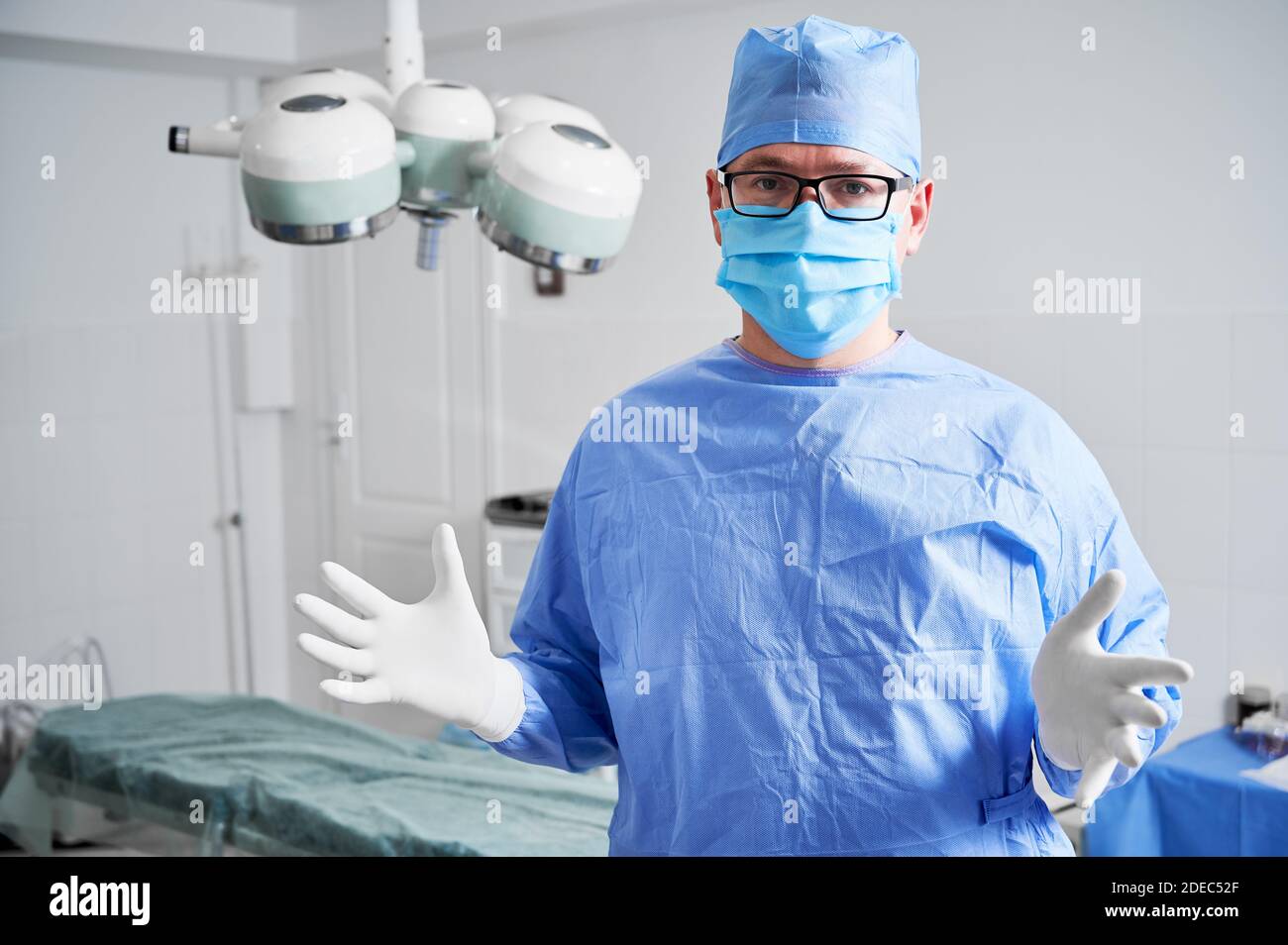 Front view of male doctor in glasses looking at camera while standing