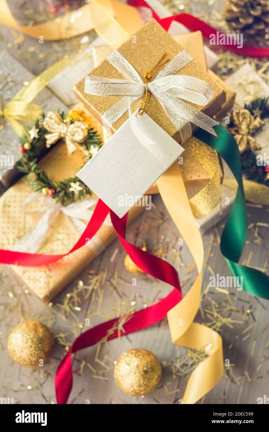 Pile of glittering silver and gold Christmas gift boxes with colorful