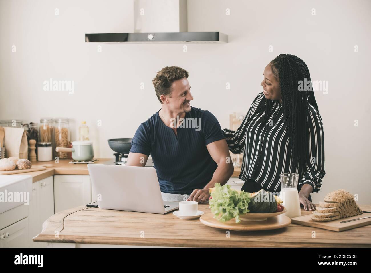 Happy married interracial couple smiling and looking at each other face in the morining at home Stock Photo