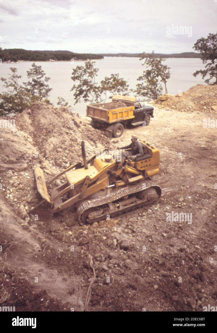 1970s Photos (1973) -  Digging foundations for a home directly above lake at Sunrise Beach on the Lake of the Ozarks. The land here falls off steeply to the shore; and this degree of soil disturbance increases likelihood of erosion  (Lake of the Ozarks Missouri area) Stock Photo