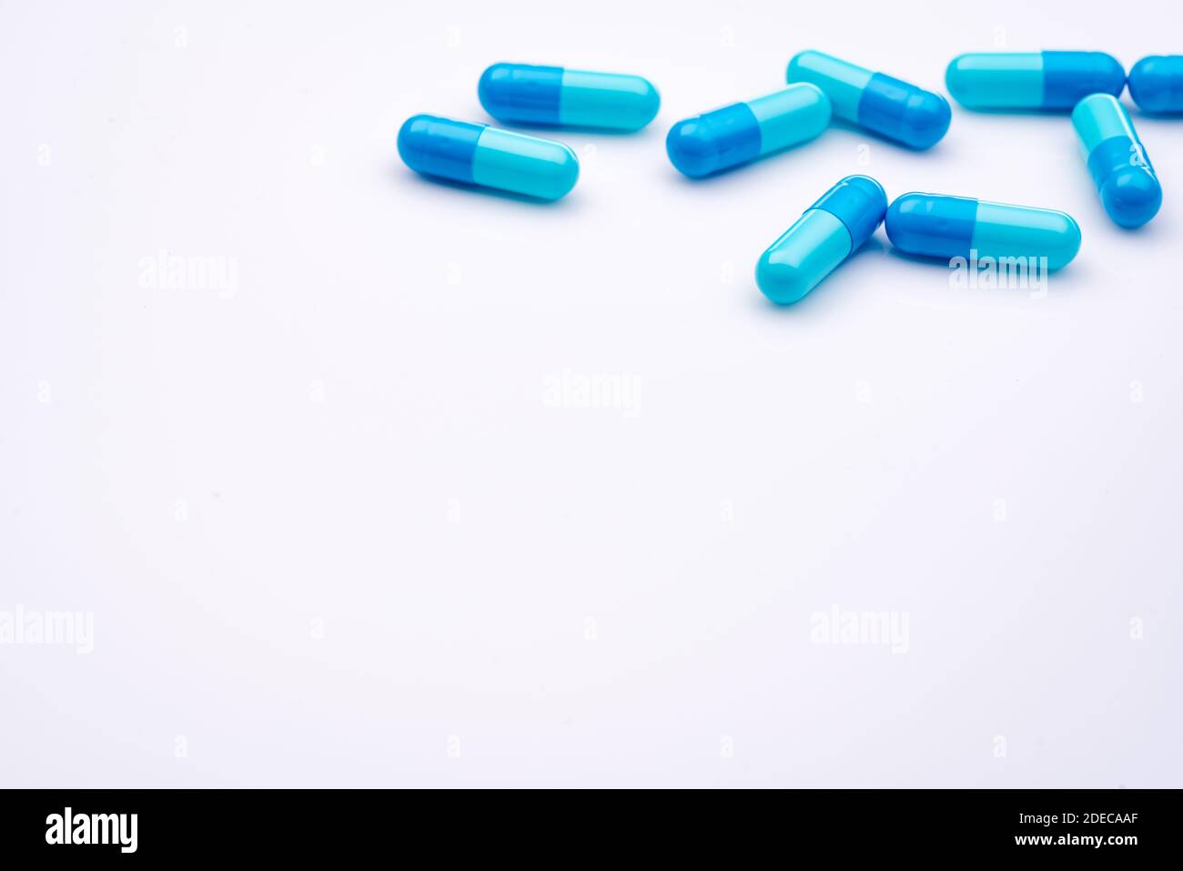 Blue capsule pills on white background. Pharmaceutical industry. Pharmacy or drugstore products. Healthcare and medicine. Health budget concept. Stock Photo