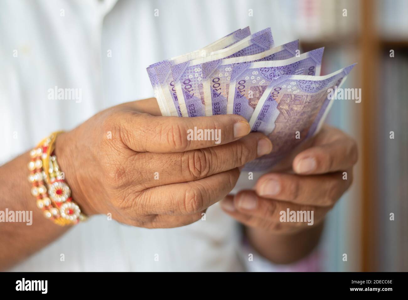 Close up hands Counting Indian Currency notes at cloth shop - Concept of back to business, profit, making money and reopen economy Stock Photo