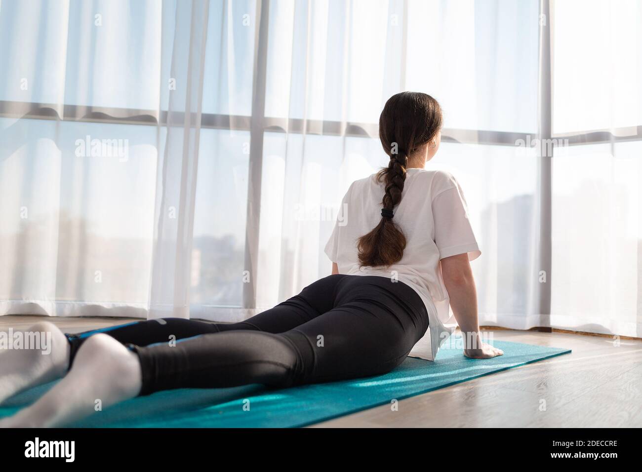 Portrait of brunette fitness girl, laying on yoga mat at home