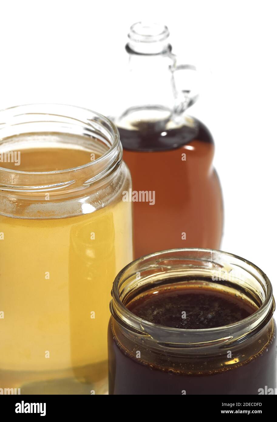 Mapple Syrup, Molasses and Honey Pots against White Background Stock