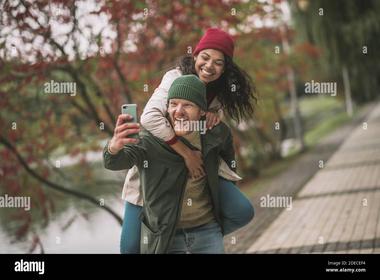 Smiling partners making emotional selfies in the autumn park Stock Photo
