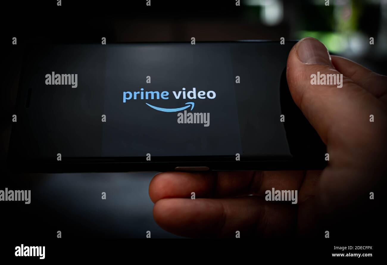 Hand holding a mobile phone with a Amazon prime video logo displayed on the screen to illustrate streaming services. High quality photo Stock Photo
