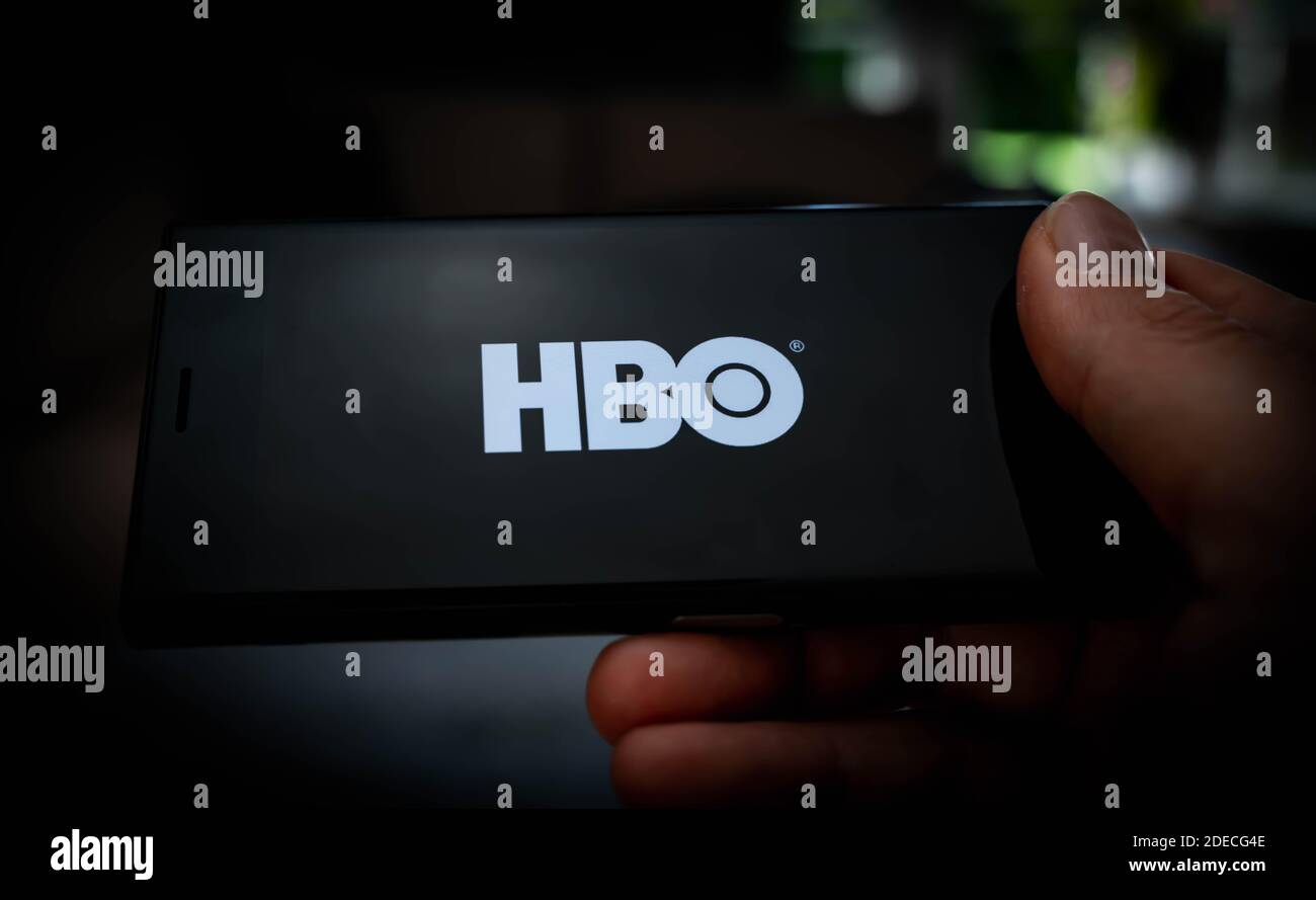 Hand holding a mobile phone with a HBO logo displayed on the screen to illustrate streaming services. High quality photo Stock Photo