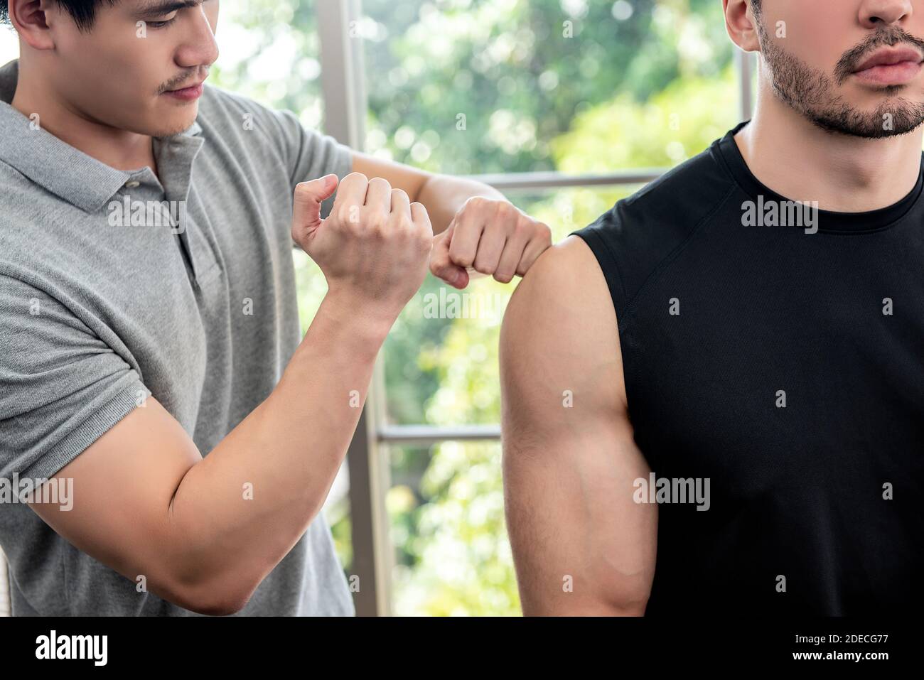 Therapist giving massage to athlete male patient by beating and pounding techniques in clinic, sports physical therapy concept Stock Photo