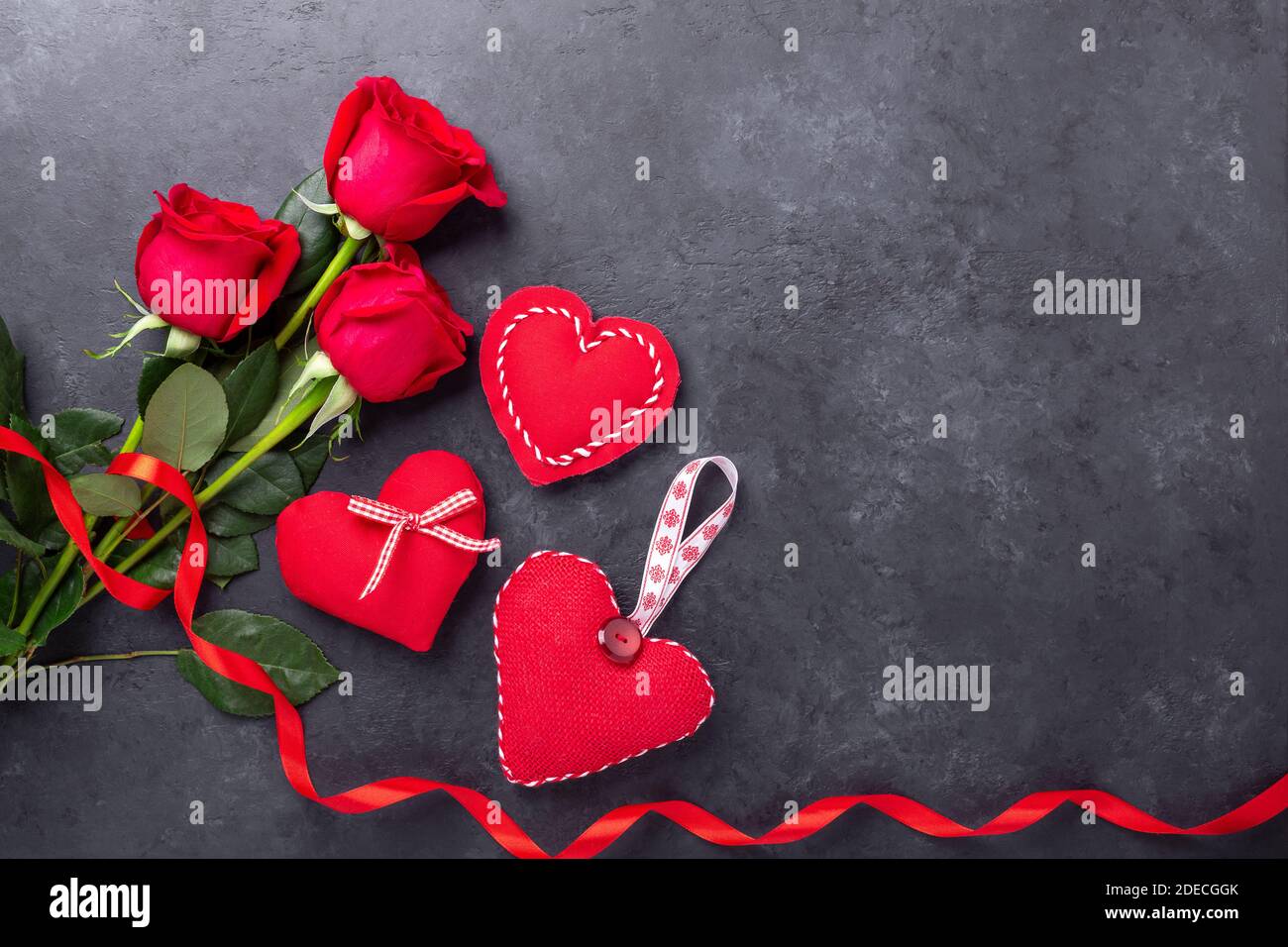 Valentines day greeting card. Red roses and textile hearts on stone background. Top view - Image Stock Photo