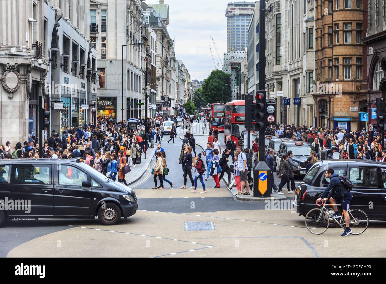 Cyclists, taxis, cars and pedestrians cross busy Oxford Street at Oxford Circus in traffic, West End, London, United Kingdom Stock Photo