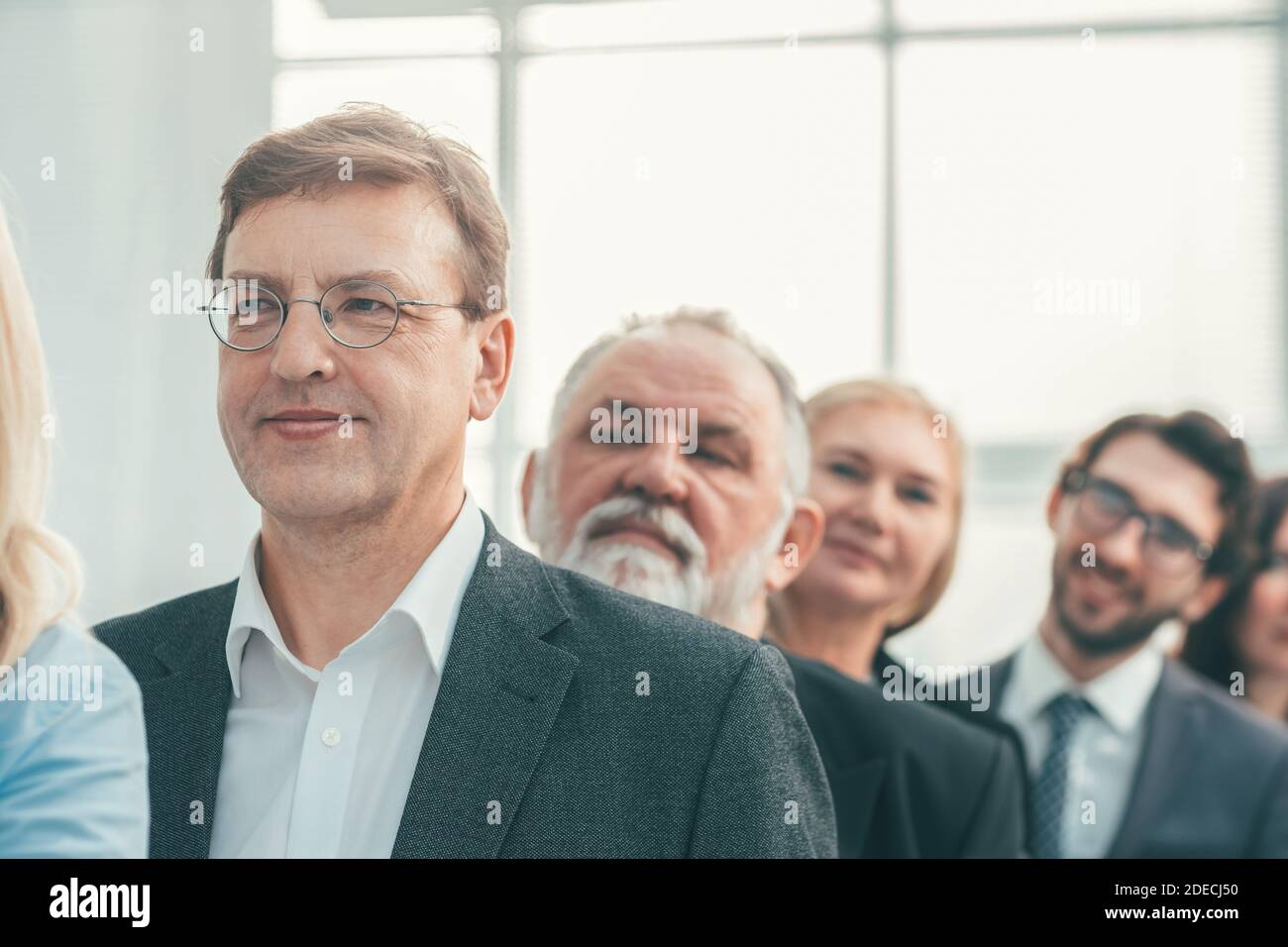 close up. smiling business people standing in a row Stock Photo - Alamy
