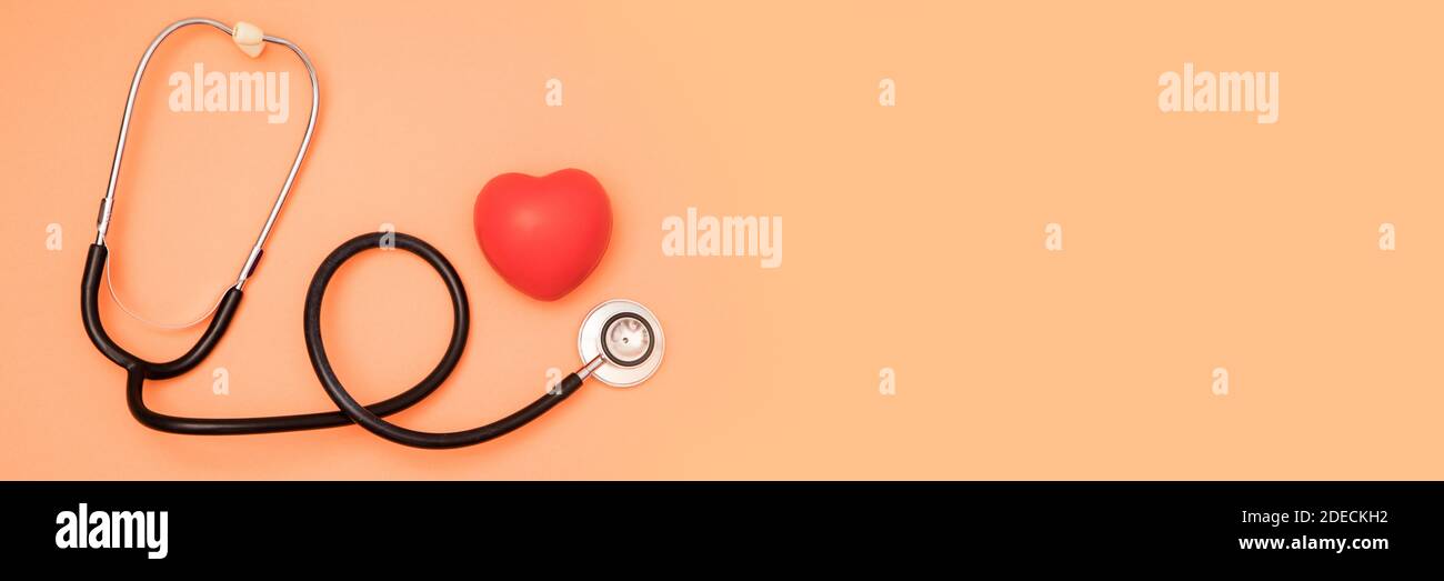 A heart with a stethoscope on red background Stock Photo - Alamy