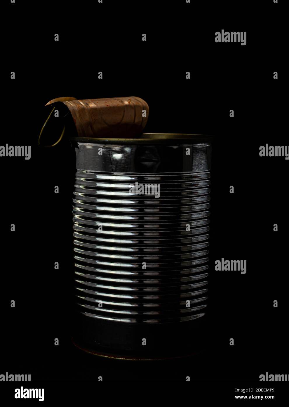 Simple used tin can with curled lid, isolated on black background